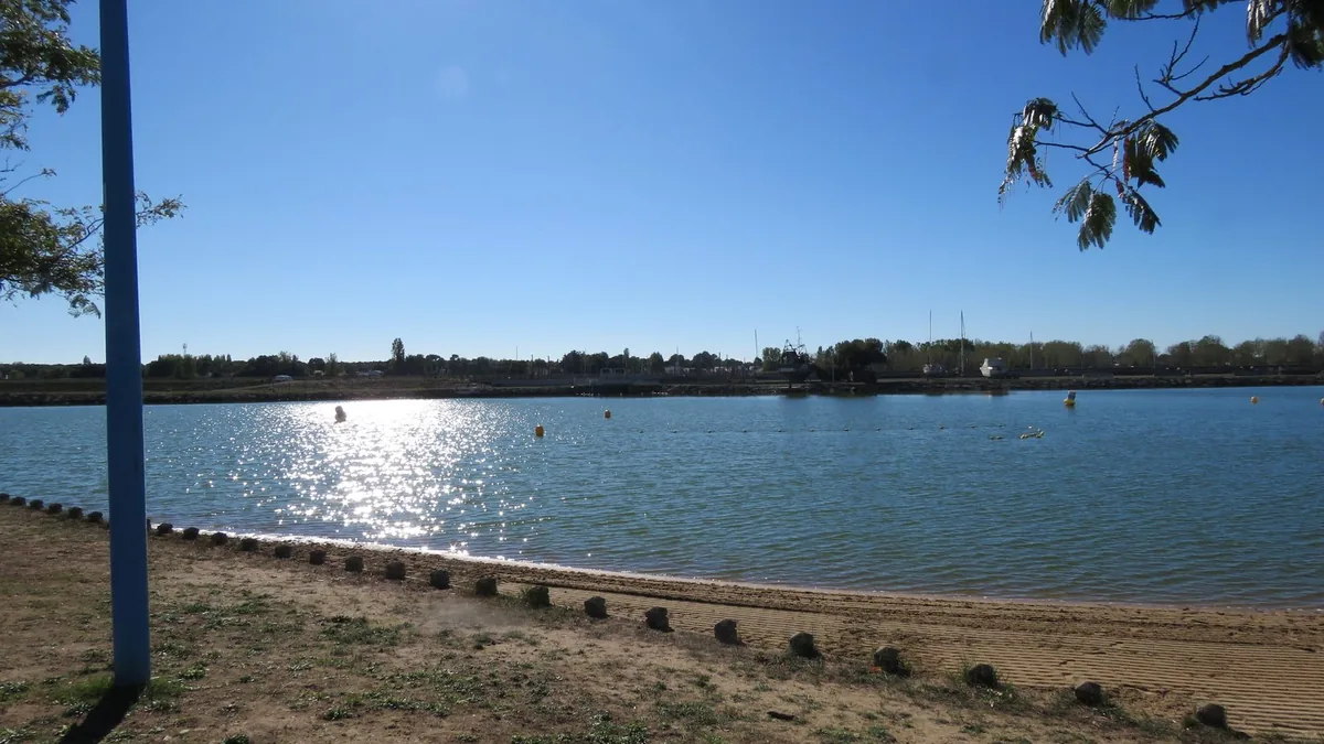 Le plan d'eau en contre-jour, depuis la plage