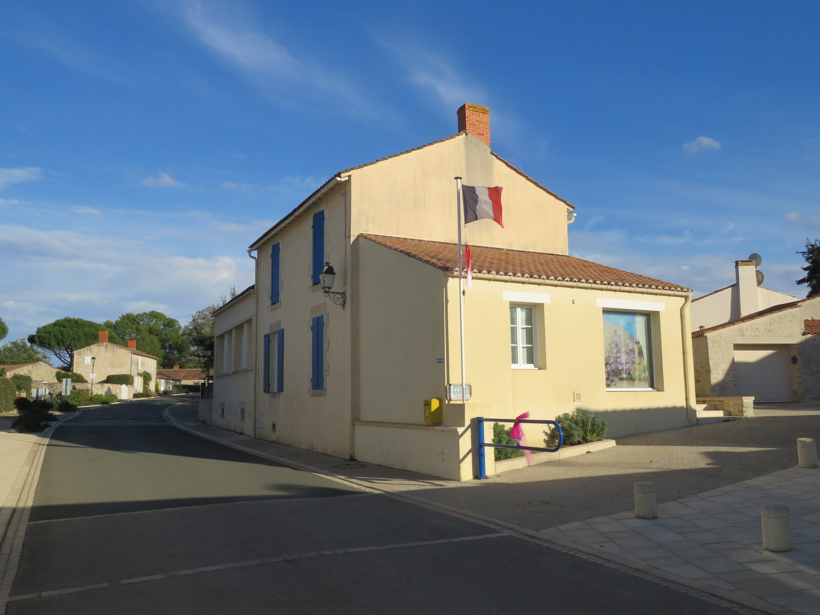 Une rue du bourg, volets bleus et ruban rose