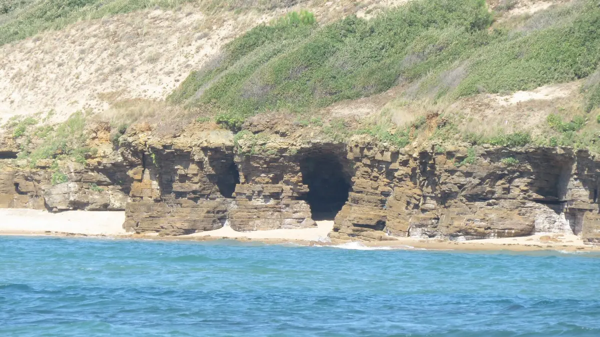 Les falaises et leur grotte, au bout de la plage du Veillon